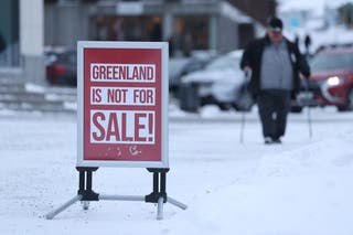 A man walks near a sign that reads: